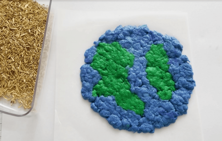 Earth Day activity shows an earth made from green and blue paper pulp and a tray of seeds.