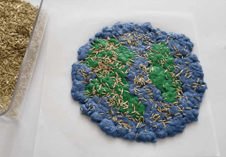 Earth Day activity shows an earth made from paper pulp with seeds sprinkled over it.
