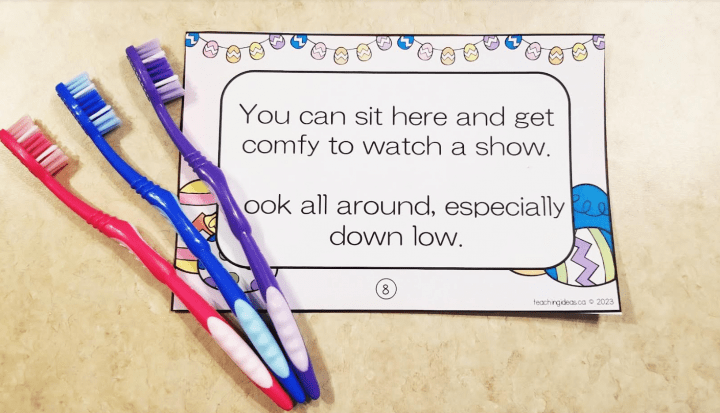 Free Easter scavenger hunt shows three toothbrushes beside a clue that says you can sit here and get comfy to watch a show look all around especially down low.