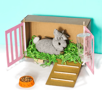 Easter arts and crafts shows a stuffed toy bunny in a DIY cage.
