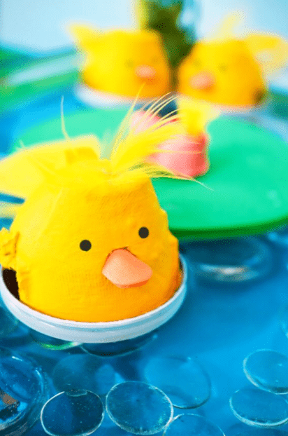 Easter STEM activities shows a yellow chick made from an egg carton on what looks like water.