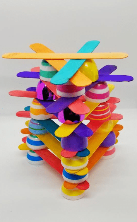 Easter STEM for kids shows a structure made from eggs and popsicle sticks.