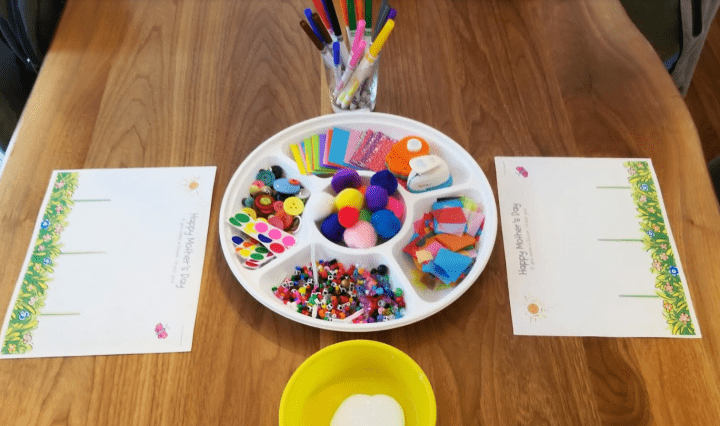 arts and crafts for kids shows a table with two printed cards and a tray of craft materials.
