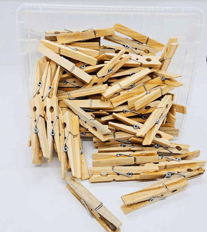 STEM activity shows a bin tipped with clothes pins.