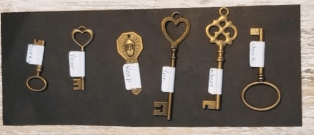 escape room puzzle ideas shows six fancy keys with tags on it with a word on each.