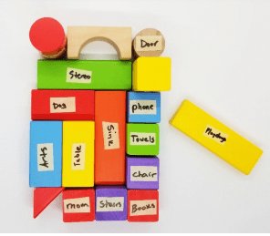 escape room puzzle ideas shows a design made from colorful wooden blocks and each block has a word on it.