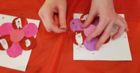 valentines day escape room shows a child scratching paint off a flower petal.