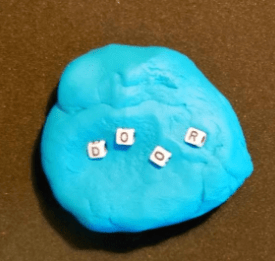 escape game for kids shows play dough with four letter blocks that spell out door.