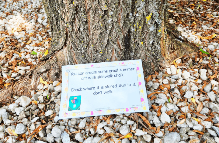 outdoor learning activity shows a printed clue at a tree trunk.