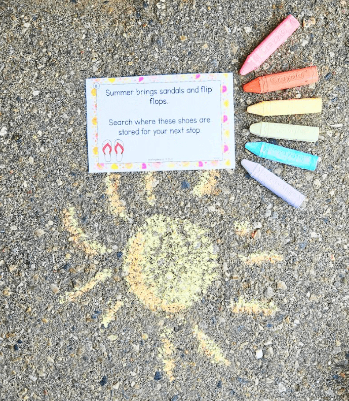 summer scavenger hunt shows a printed clue surrounded by colorful chalk and drawings.