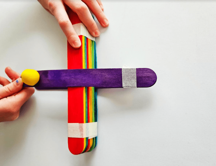 popsicle stick stem shows a child ready to launch a diy catapult.