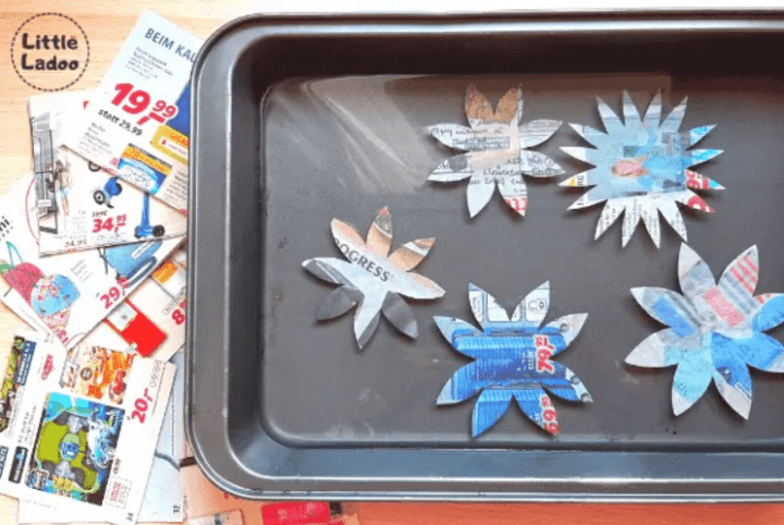 paper flowers shows a cookie sheet with five flower cut outs on top.