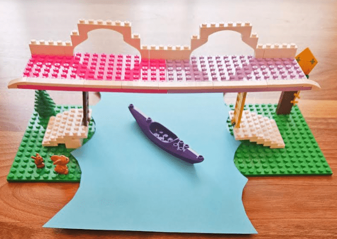build a bridge stem challenge shows a bridge that lifts and a purple lego boat going under it.