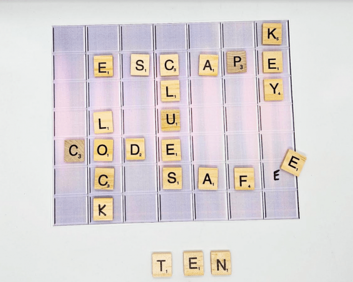 build your own escape room shows scrabble pieces on a paper cut out and three pieces left over that spell out ten.