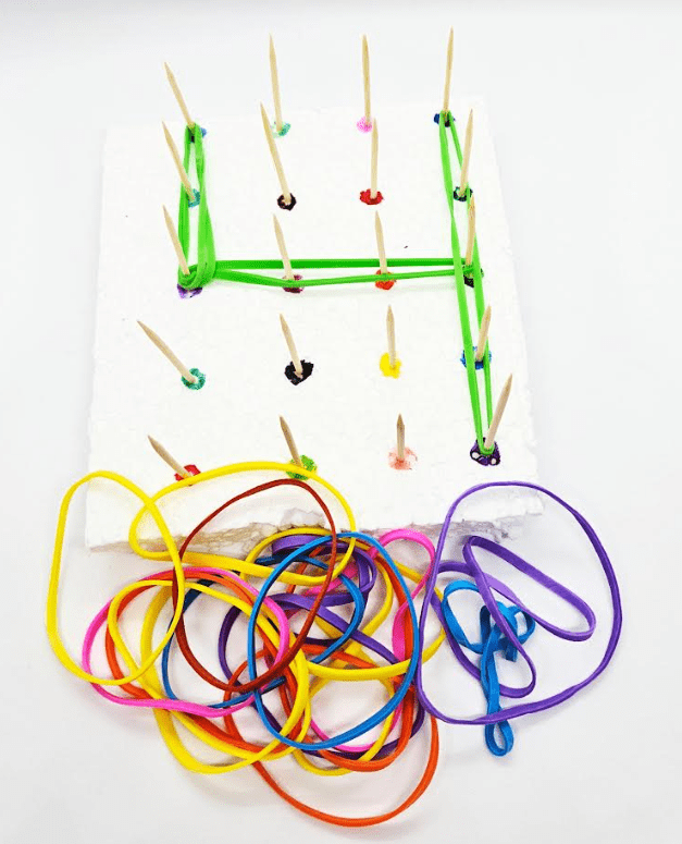escape room for kids shows a peg board type board with elastics on the sticks forming the number 4.