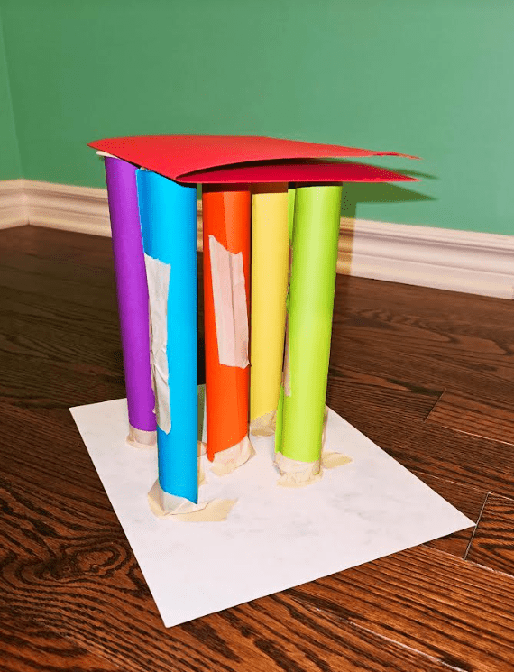STEM project shows five colorful rolls stuck to paper with one sheet on top creating a tower.