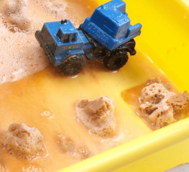 science experiments for kids shows a toy truck with fizzing brown piles.