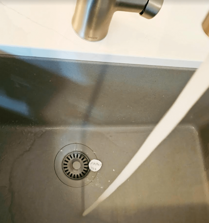 escape room clues shows a running tap and a piece of paper fallen into the drain.