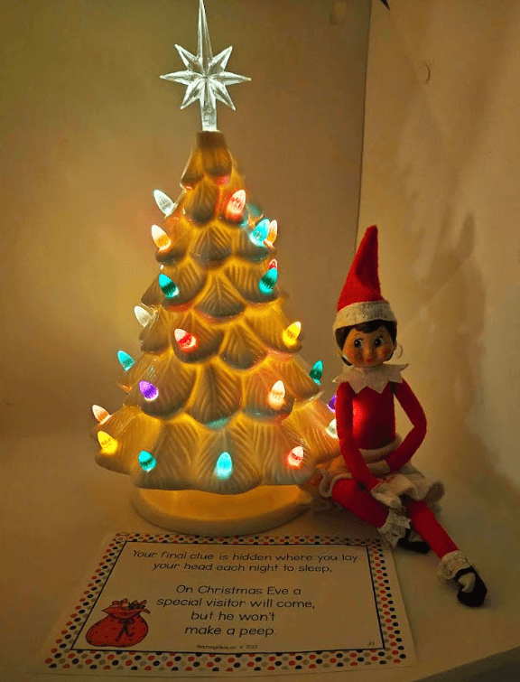 Best Christmas Scavenger hunt shows an elf by a light of tree.