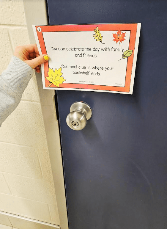 thanksgiving scavenger hunt shows a child holding a sheet of paper with a scavenger hunt clue in front of a door.