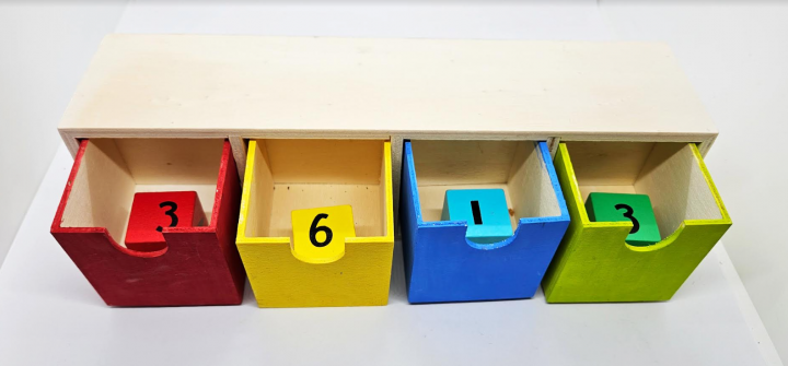 escape room for kids shows four open boxes each with a number block inside.