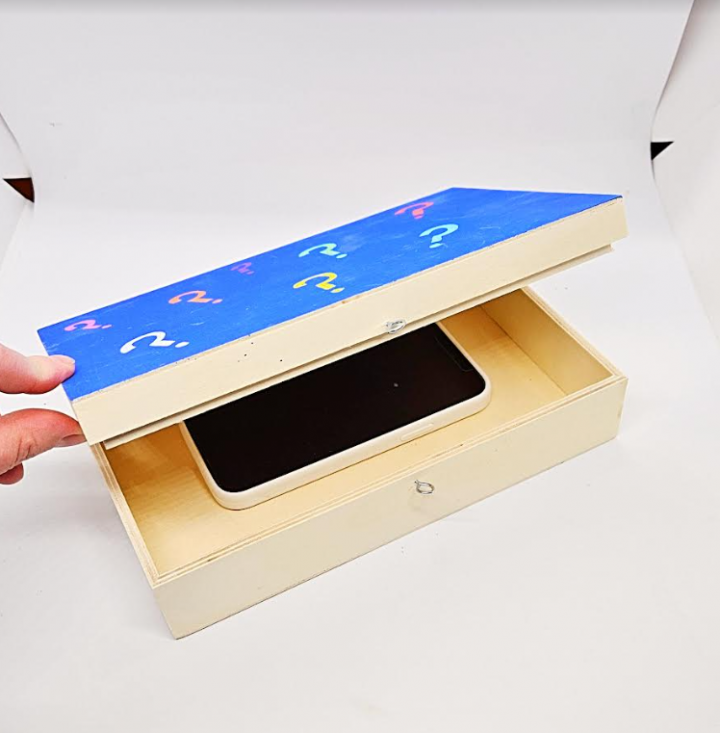 escape room game for kids shows a box with a cell phone inside.