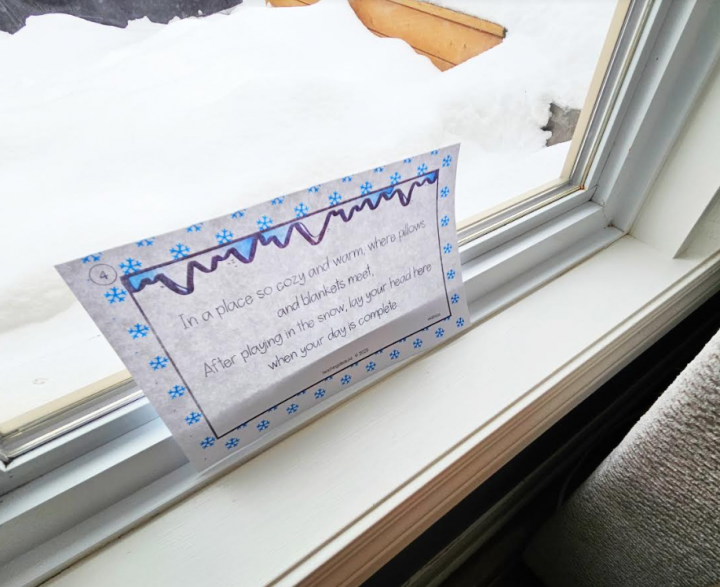 winter scavenger hunt shows a printed clue in a window.