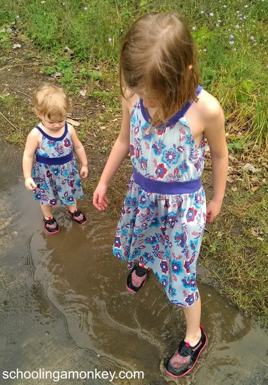 science nature walk shows two children playing in a puddle.