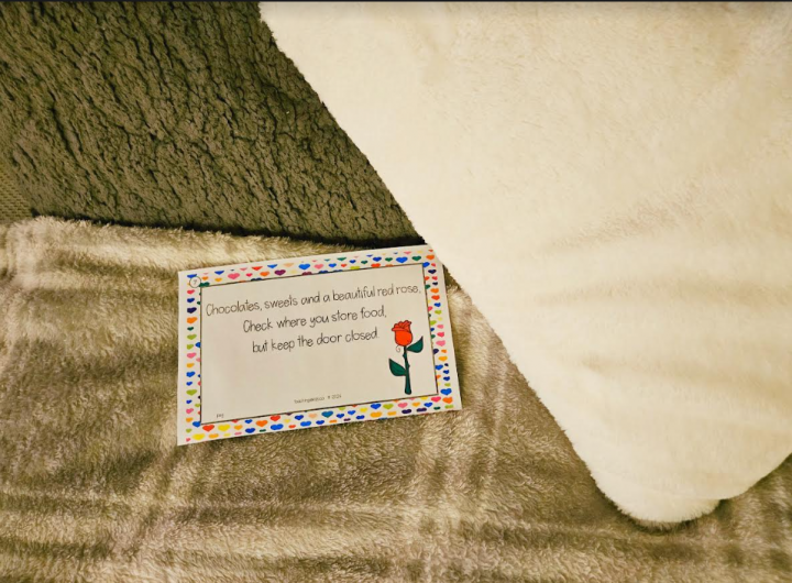valentines day scavenger hunt shows a riddle page on a bed.
