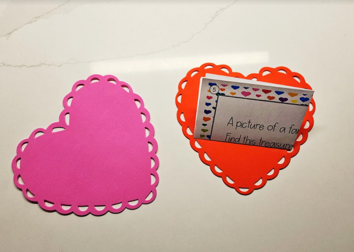 valentines day scavenger hunt shows two foam hearts with a folded clue inside.