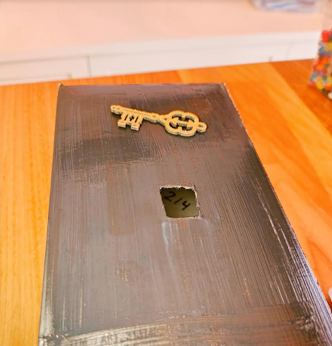 diy escape room at home shows a black box with a hole cut in the top and the number 214 slightly visible through the top.
