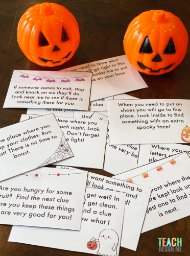 free printable scavenger hunt shows a pile of riddles and two pumpkin decorations.