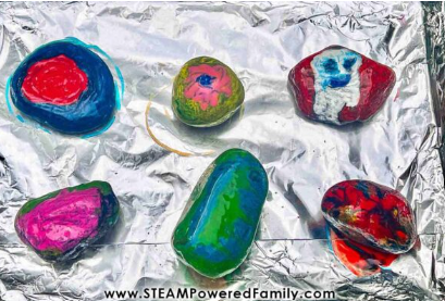 Summer Outdoor Learning Activities shows six rocks on a tray with melted crayon on it.