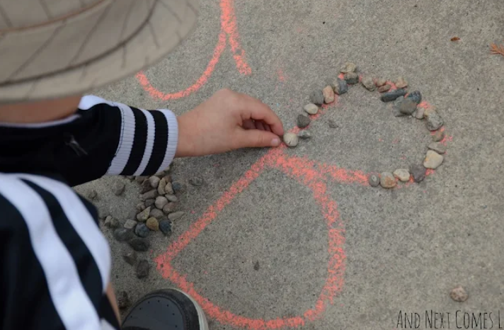 alphabet activity for kids shows a child tracing the letter B in stones.