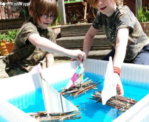stick raft stem shows two kids playing with stick rafts in water.