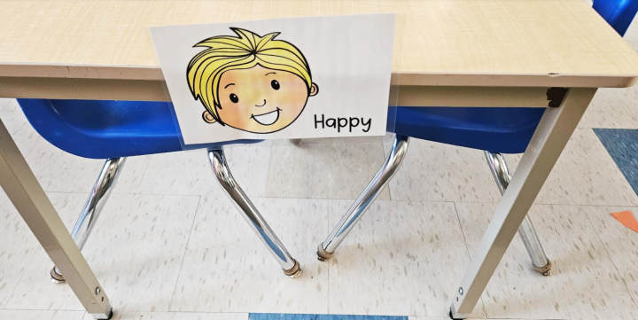 social emotional learning shows an image of a happy face on a table for children to choose their emotion.