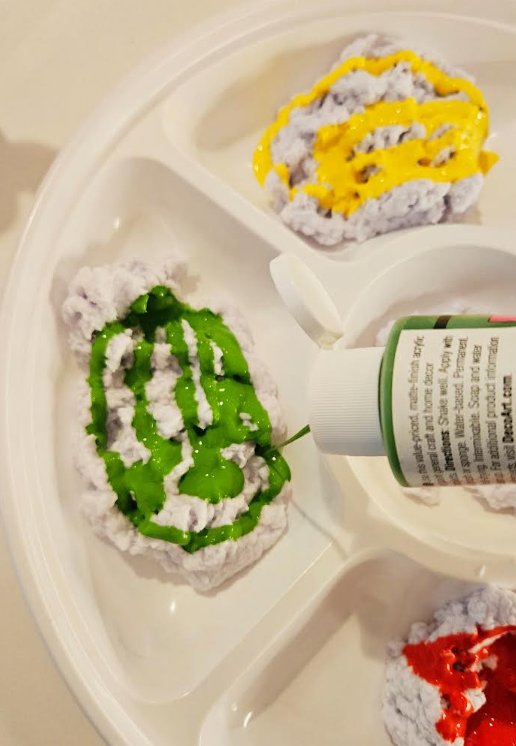 paper mache art shows the pulp and gree paint being added.