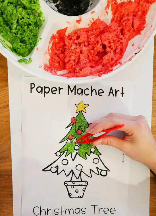 recycled paper mache Christmas tree craft shows a printed image of a tree and paper mache pulp being placed on it.