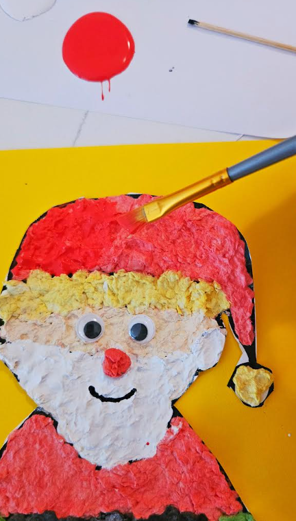arts and crafts for kids shows a Santa craft image being painted red.