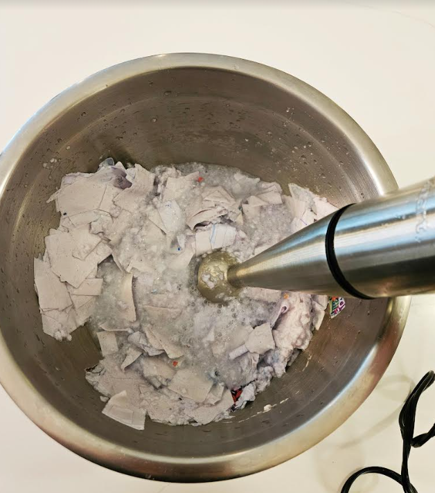 paper mache shows ripped up paper being blended with a hand mixer.