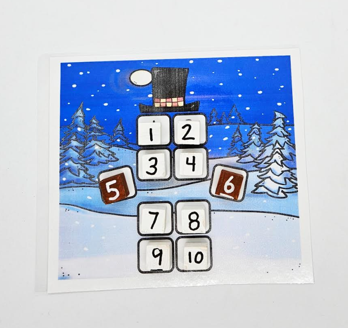 math activity for young children shows painted blocks with numbers set to create a snowman image.