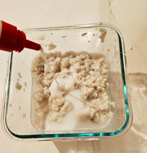 messy play shows white glue being added to a mixture.