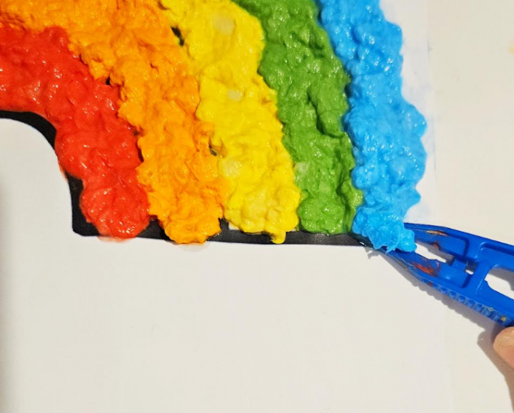 art for kids shows a child using tweezer to add pulp to a part of their art.