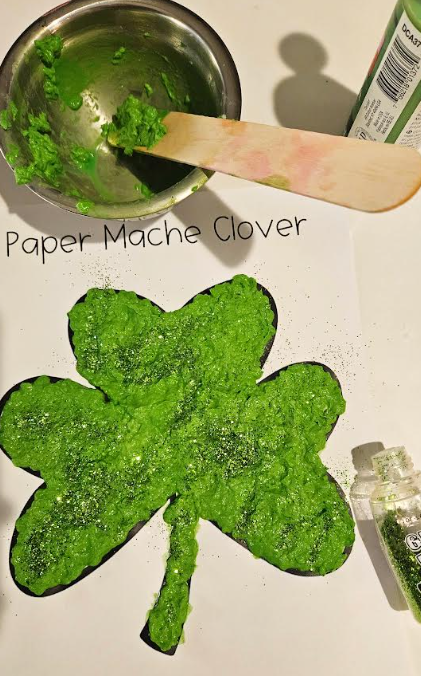 holiday craft for kids shows a shamrock that has some glitter on it.