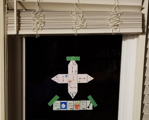 printable puzzles shows a shape cut out and placed in a window.