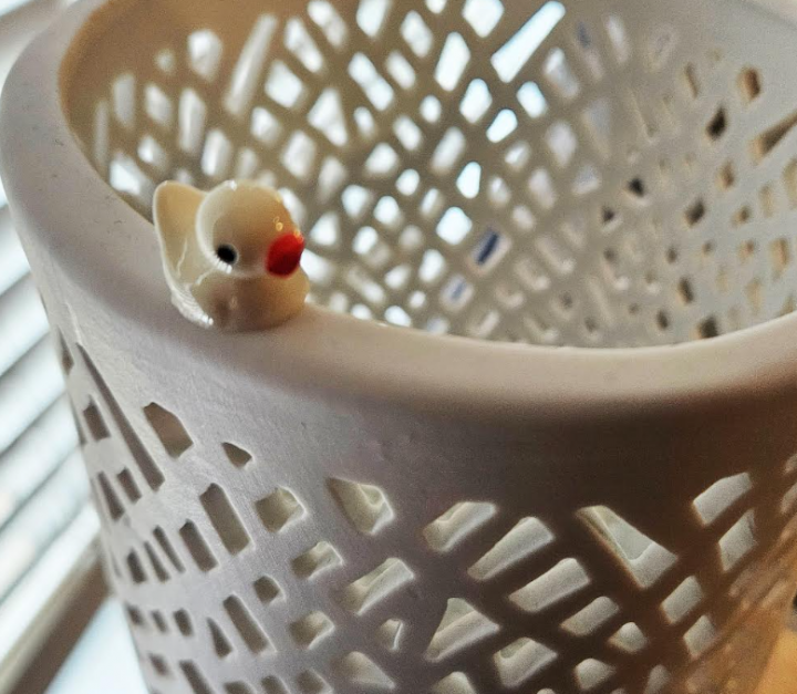 spring activity for kids shows a mini white plastic duck on a decorative vase.