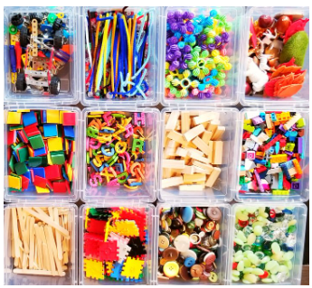 loose parts play shows twelve bins with craft supplies and other building materials.