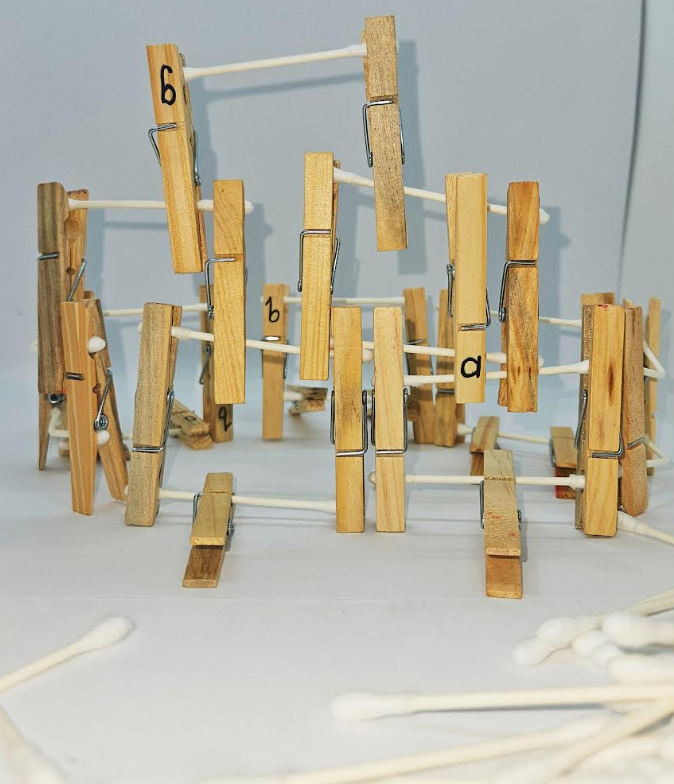 easy stem challenge for kids with free task card shows a structure made from clothes pins and cotton swabs.